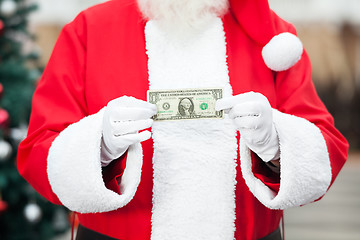 Image showing Santa Claus Holding One Dollar Note