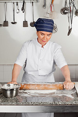 Image showing Female Chef Rolling Dough At Kitchen Counter