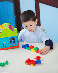 Image showing Boy Playing With Toys At Desk In Preschool