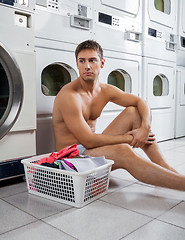 Image showing Bored Man With Laundry Basket Waiting To Wash Clothes