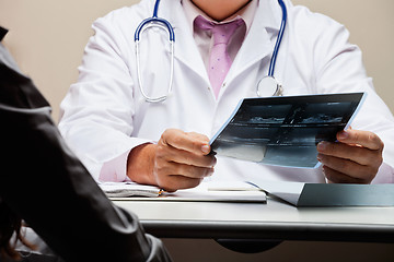 Image showing Radiologist At Desk Holding X-ray