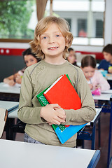 Image showing Schoolboy With Books Standing At Desk