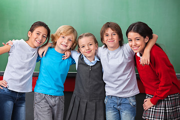 Image showing Cute Schoolchildren With Arms Around Standing Together In Classr