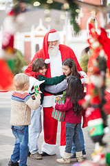 Image showing Children Embracing Santa Claus
