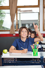 Image showing Happy Schoolboy Raising Hand In Classroom