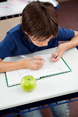 Image showing Schoolboy Copying From Cheat Sheet During Examination