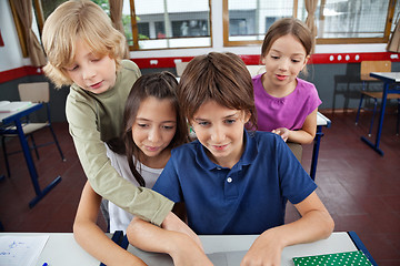 Image showing Cute Schoolchildren Using Laptop At Desk
