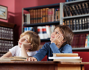 Image showing Schoolboys Looking Away While Sitting In Library