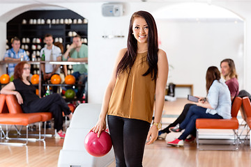 Image showing Happy Young Woman Holding Bowling Ball in Club