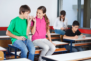 Image showing Teenage Boy And Girl Listening Music In Classroom