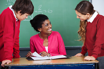 Image showing Teacher Discussing With Students At Desk