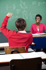 Image showing Teenage Schoolboy Raising Hand At Desk