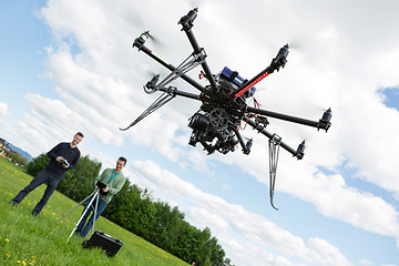 Image showing Technicians Operating UAV Helicopter in Park
