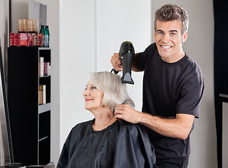 Image showing Male Hairdresser With Dryer Setting Customer's Hair