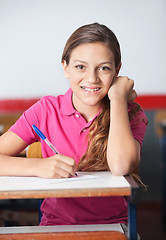 Image showing Teenage Schoolgirl Writing At Desk