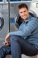 Image showing Man Listening To Music At Laundromat