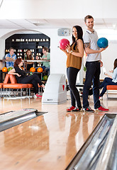 Image showing Man And Woman Standing With Bowling Balls in Club