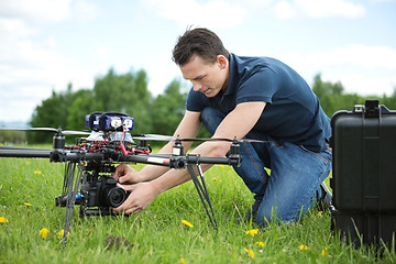 Image showing Technician Fixing Camera On UAV Helicopter