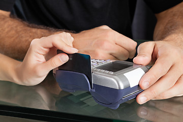 Image showing Hand Swiping Credit Card Through Terminal At Salon