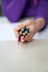 Image showing Girl Holding Bunch Of Colored Pencils At Desk