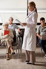 Image showing Doctor Reading File With People In Lobby