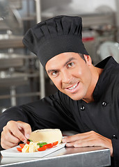 Image showing Happy Chef Garnishing Dish