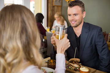 Image showing Businessman Toasting Juice Glasses With Female Colleague