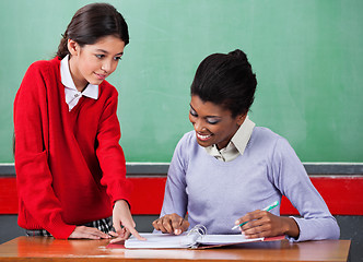 Image showing Schoolgirl Asking Question To Female Teacher At Desk