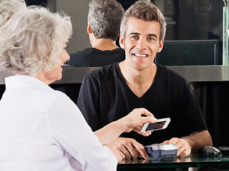 Image showing Hairdresser With Woman Paying Through Cellphone