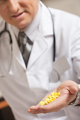 Image showing Doctor Holding Yellow Pills