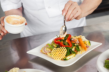 Image showing Female Chef Garnishing Dish At Counter