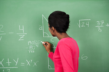 Image showing Female Teacher Solving Mathematics On Board