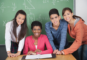 Image showing Teacher With High School Students At Desk