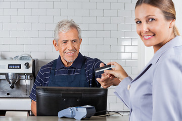 Image showing Female Customer Giving Credit Card To Senior Cashier