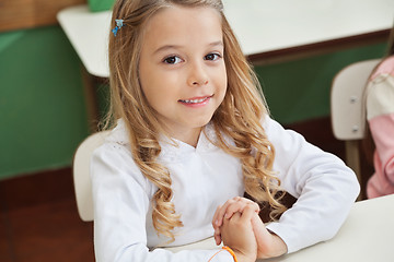 Image showing Girl Sitting With Hands Clasped In Classroom