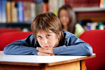 Image showing Portrait Of Bored Schoolboy Leaning On Table In Library