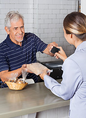 Image showing Female Customer Making Credit Card Payment At Counter