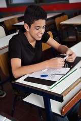 Image showing Schoolboy Copying From Cheat Sheet At Desk