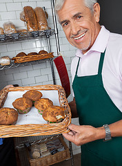 Image showing Salesman Displaying Tray Of Cupcakes