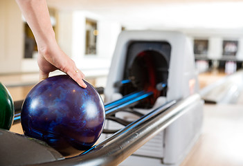 Image showing Man's Hand Picking Up Bowling Ball From Rack