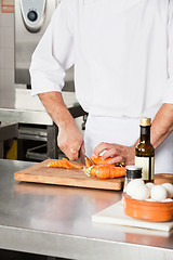 Image showing Chef Cutting Carrots At Kitchen Counter