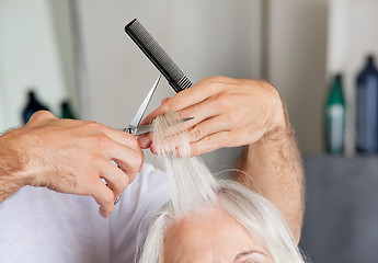 Image showing Hairdresser's Hand Cutting Hair In Parlor