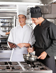 Image showing Chefs With Digital Computer Cooking Food