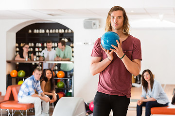 Image showing Confident Man Holding Bowling Ball in Club