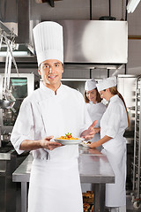 Image showing Confident Chef Presenting Dish In Commercial Kitchen