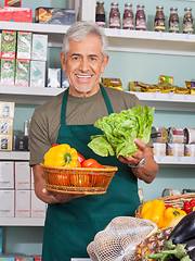 Image showing Senior Salesman Selling Vegetables In Store