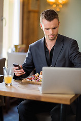 Image showing Businessman With Cellphone And Laptop In Restaurant