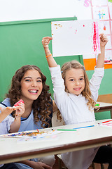 Image showing Teacher With Girl Showing Drawing At Desk