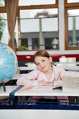 Image showing Cute Girl Sitting With Books And Globe At Desk