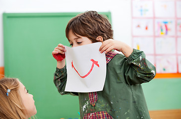 Image showing Boy Holding Paper With Smile Drawn On It